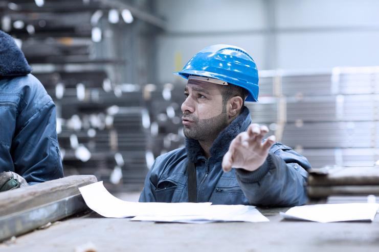 Kompetenz in der Anarbeitung Mitarbeiter mit Helm im Stahlgroßhandel